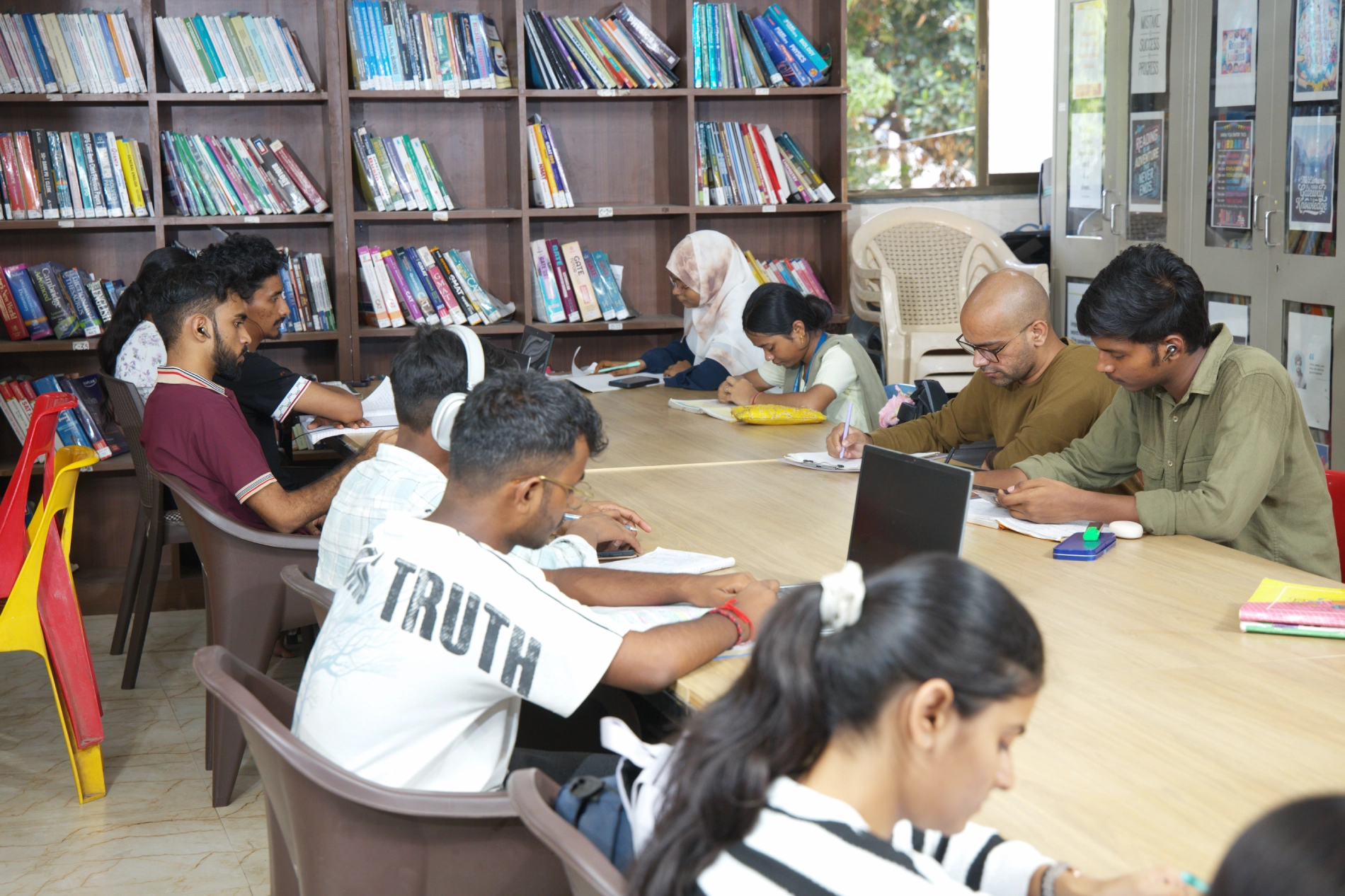 Students reading amid the library book shelves